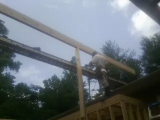 Carpenter setting a ridge beam over a new addition frame — Ice Dam Removal by Roofing Brothers in Loch Sheldrake