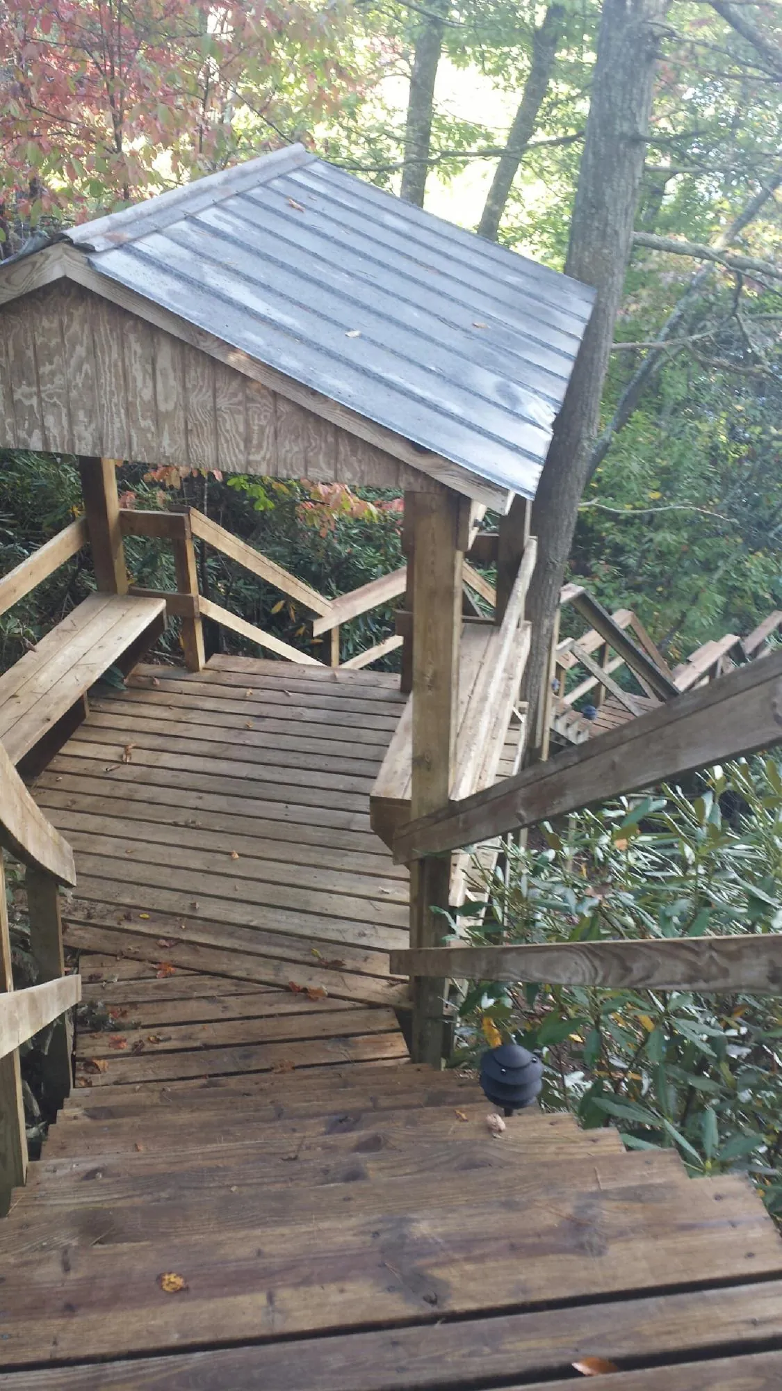 Metal roofed shelter over wooden steps on a wooded walkway — Skylight Repair & Installation work by our crew in Loch Sheldrake