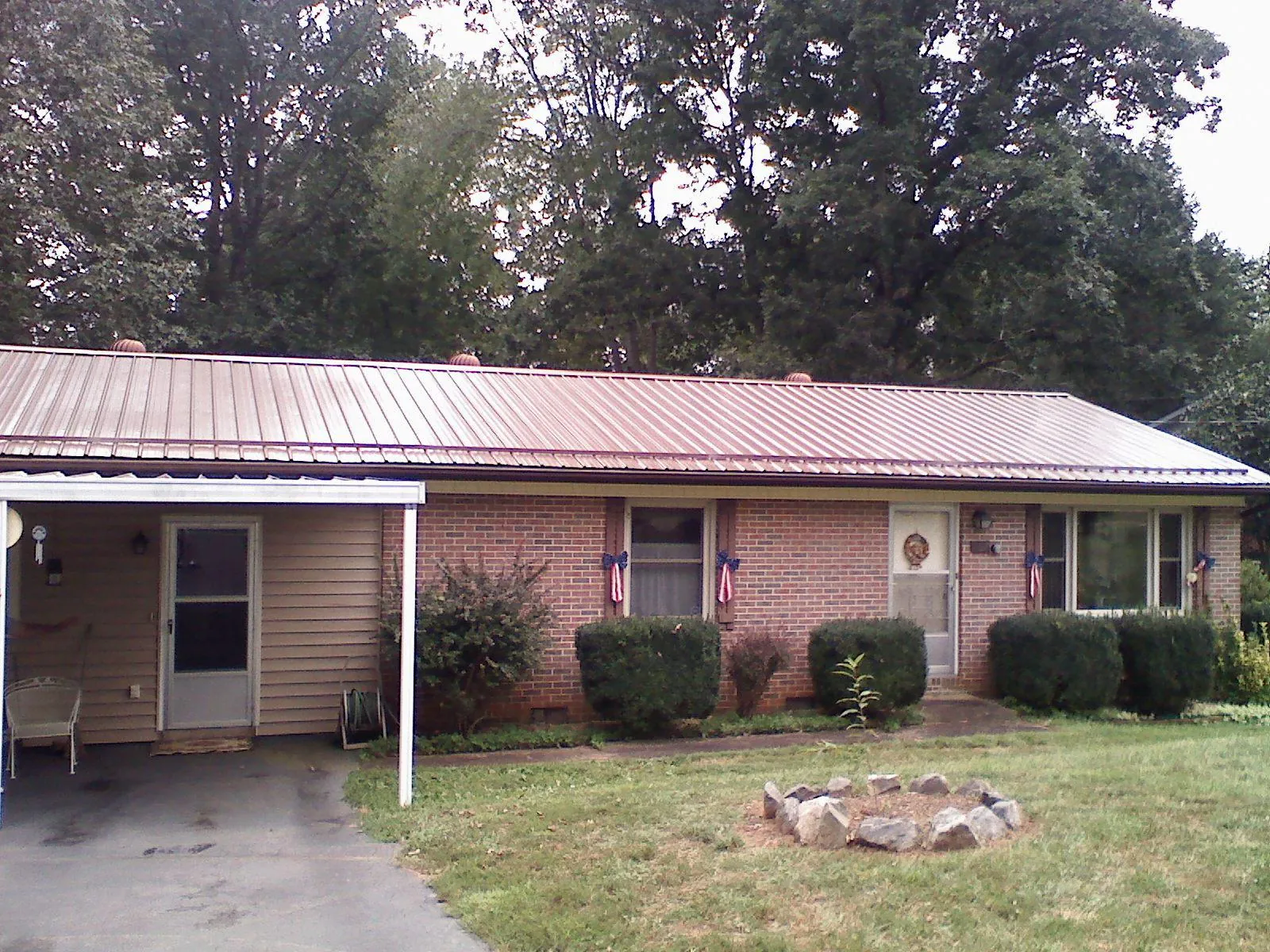 Bronze metal roof and carport on a brick ranch home — Roof Repair work by our crew in Loch Sheldrake
